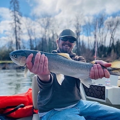 Man aboard boat holds up fish caught on trip