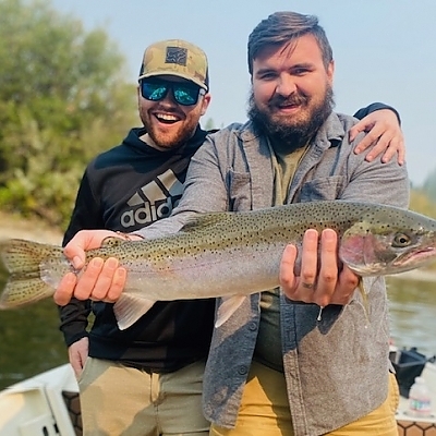 Two men hold up catch on trip