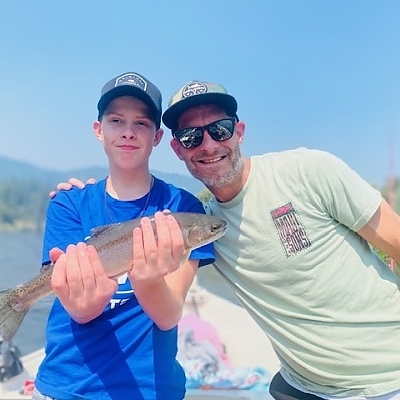 Father and son pose with fish