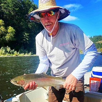 Older gentleman holds up fish in two hands