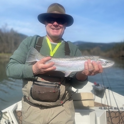 Man holds up fish caught on trip