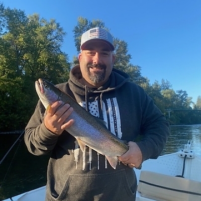 Man holds up fish caught on trip