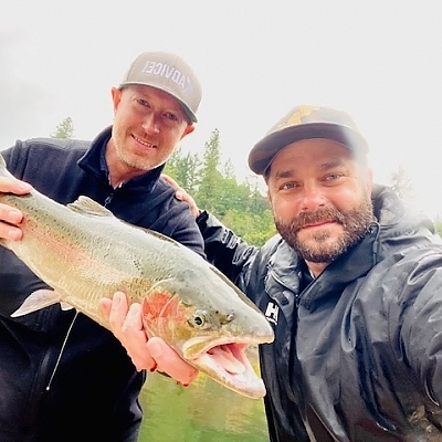 Two fishermen pose on boat