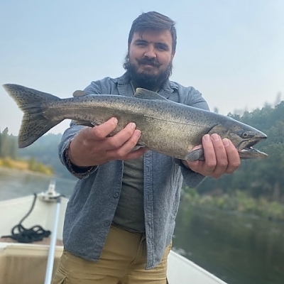 Man holds up fish caught on trip