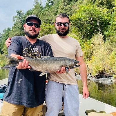 Two fishermen hold up their catch