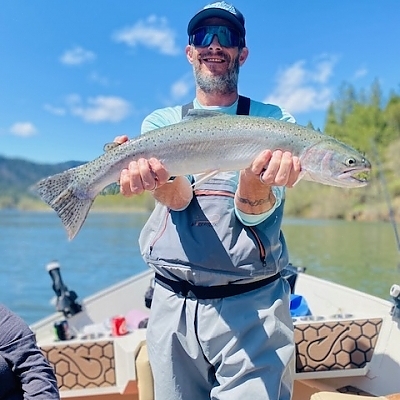 Man holds up fish caught on trip